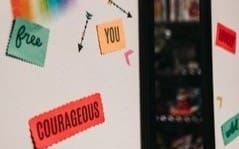 A refrigerator with magnets on it and the words courageous