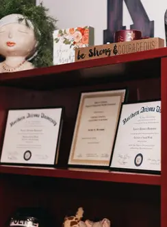 A shelf with three certificates on it