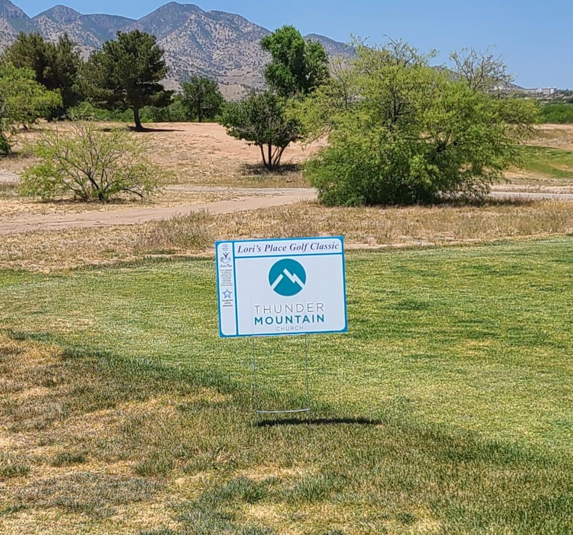 A sign in the middle of an open field.