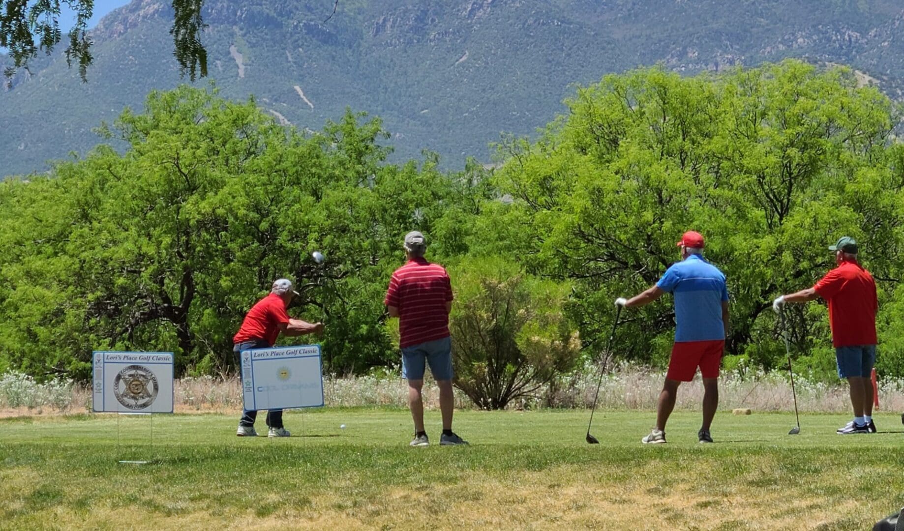 Three men are playing golf on a green.